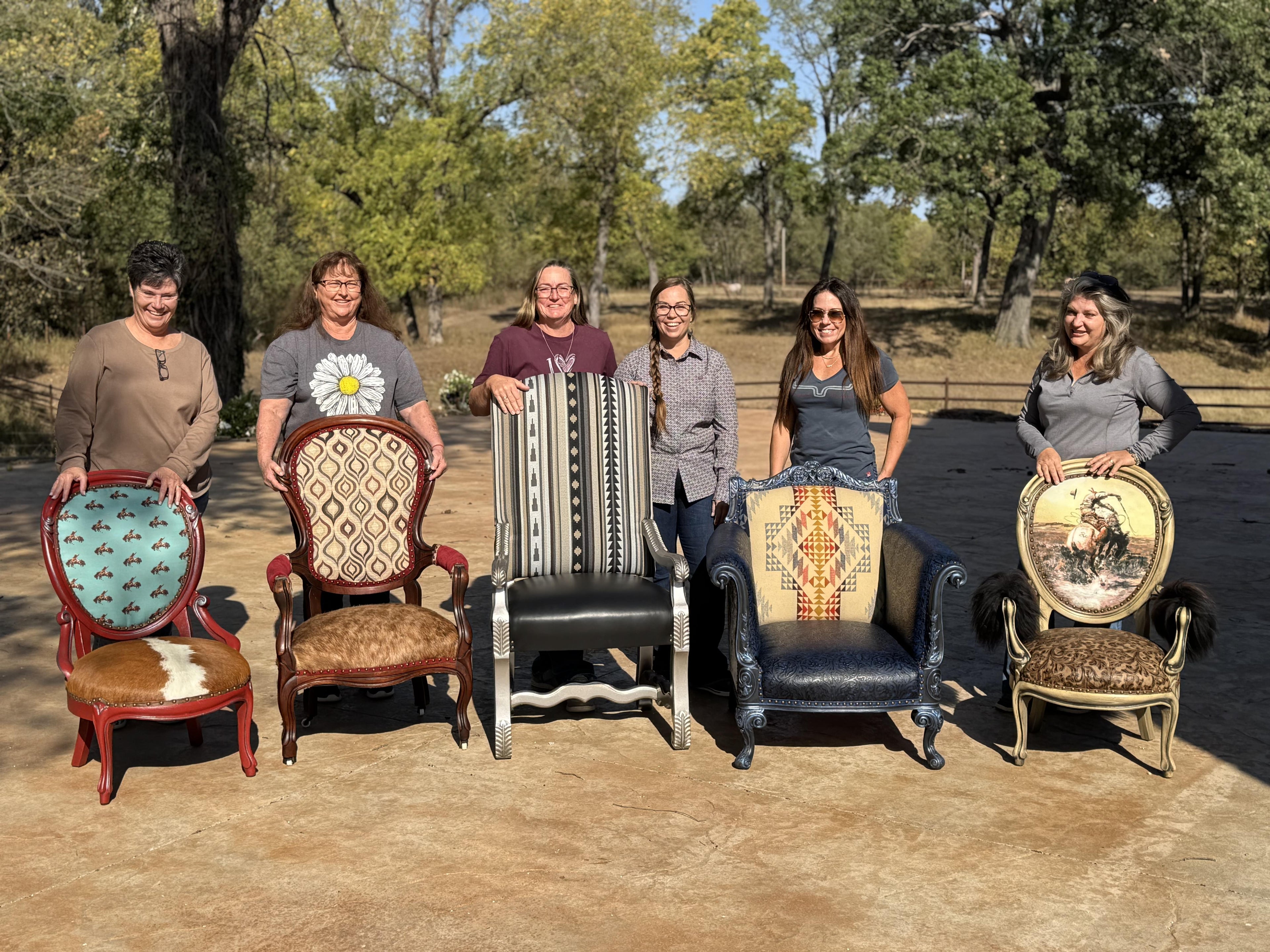 Group of upholstery workshop participants with their completed chairs