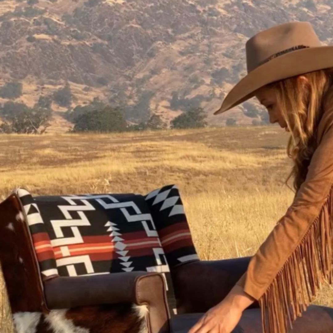 Sierra with an upholstered chair outside with scenic mountain backdrop