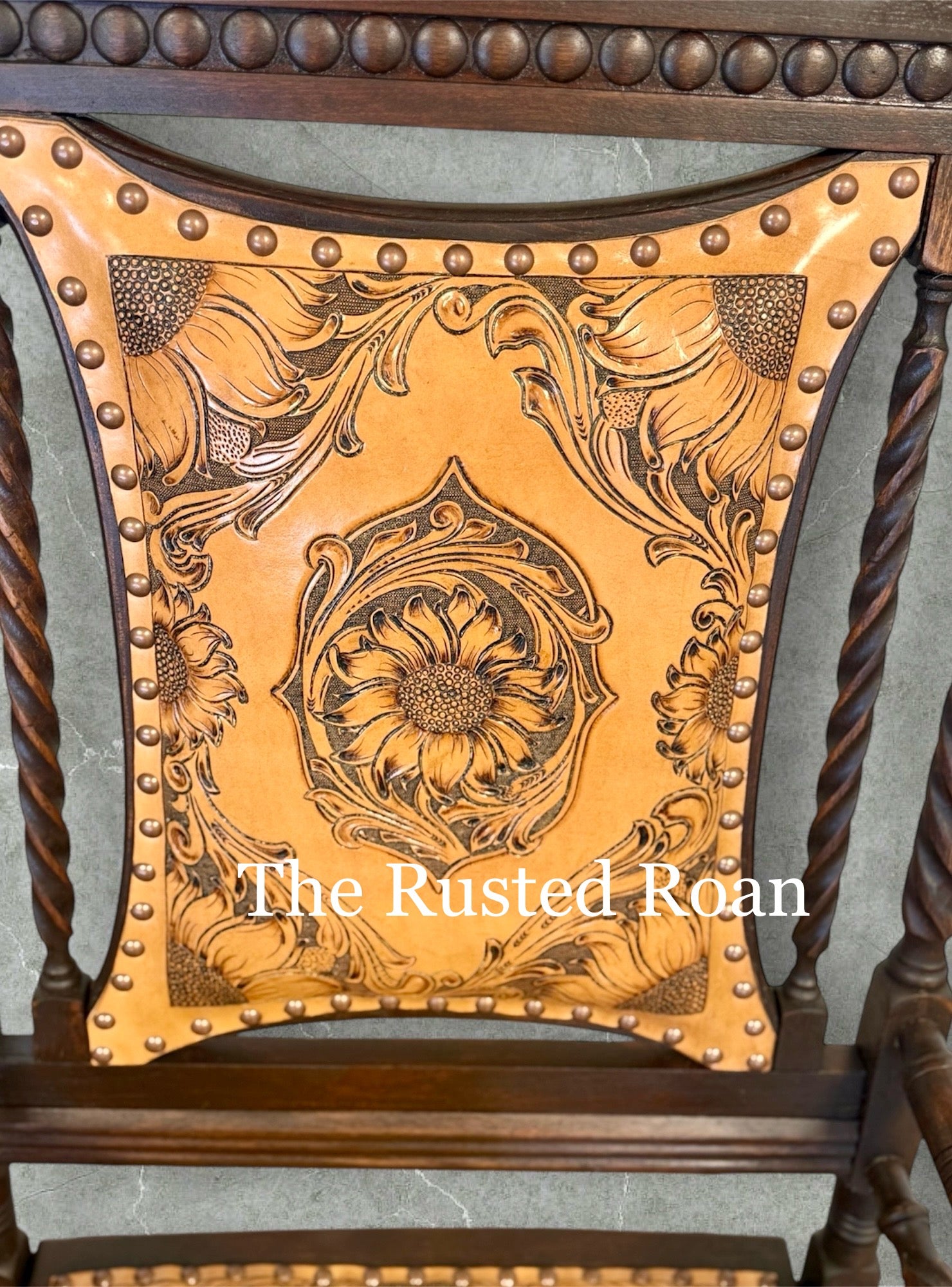 hand tooled sunflower leather upholstered rocking chair inside back close up view of the tooling